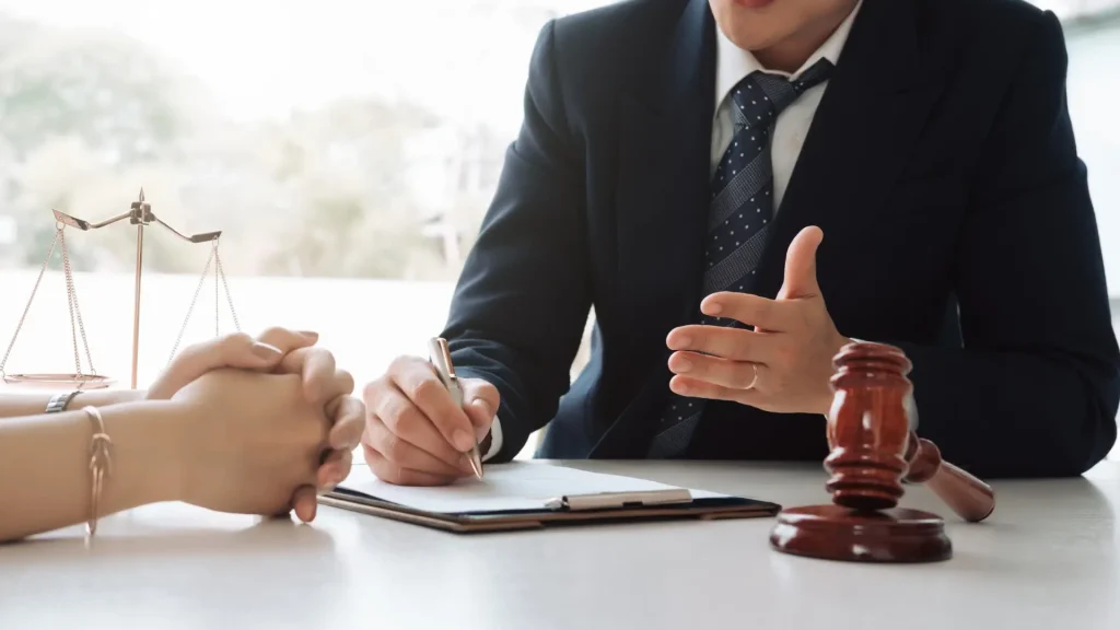 Close-up of a lawyer discussing legal matters with a client, with a gavel and legal documents on the table