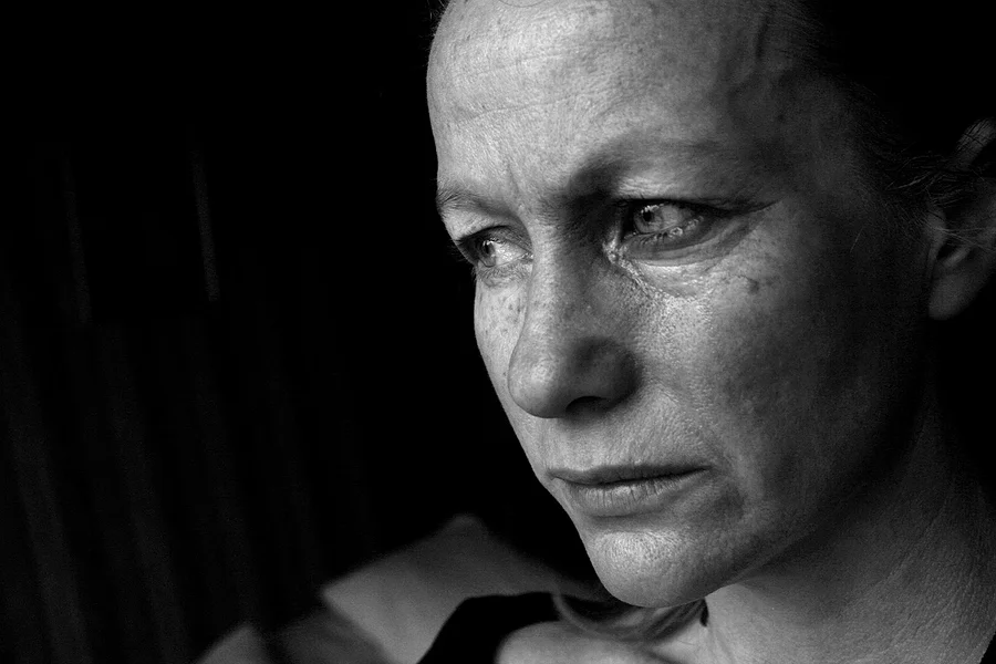 Black and white close-up on a woman's face, holding back tears