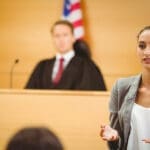 Lawyer delivers statement in a courtroom with a judge listening attentively