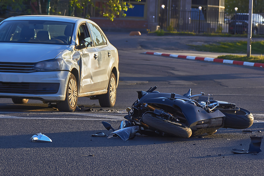 A wrecked motorcycle laying on the ground after an accident