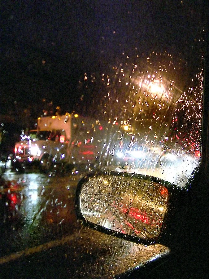 A Car Window with rain drop on the main Street