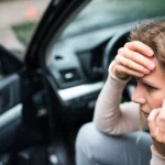 Stressed woman talking on the phone after a car accident