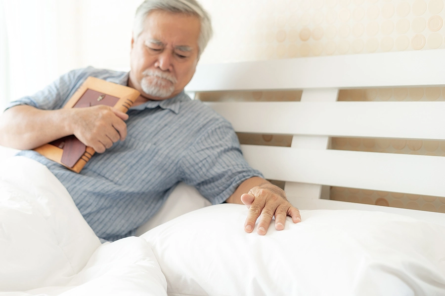 Older man laying in bed mourning the wrongful death of his spouse after a Florida accident