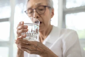 An Old Person Drinking Water from the glass Cup