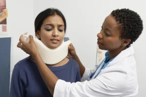 Doctor placing a neck collar on patient