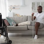 Man sits on his couch with his leg in a cast due to an injury caused by a personal injury accident