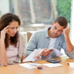 Wife and husband looking at medical bills feeling stressed about how much a traumatic brain injury costs