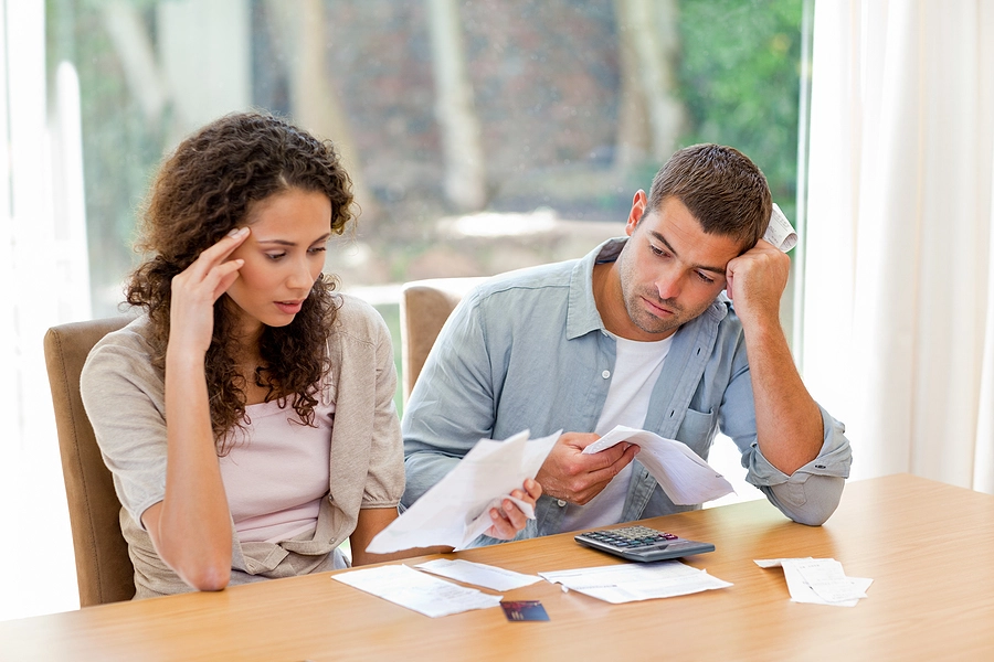 Wife and husband looking at medical bills feeling stressed about how much a traumatic brain injury costs