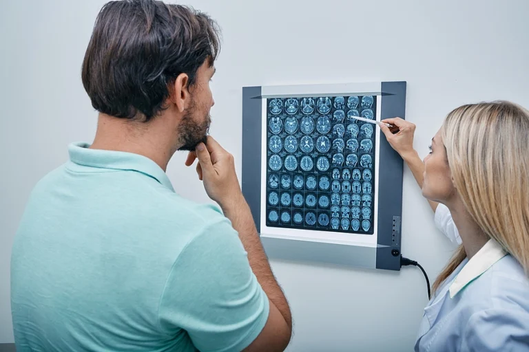 Doctor explains scan results to a veteran with a traumatic brain injury who may benefit from new amendments on how the military handles TBIs