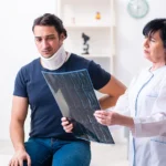 Patient with a neck brace looking at a scan with a doctor after a car accident