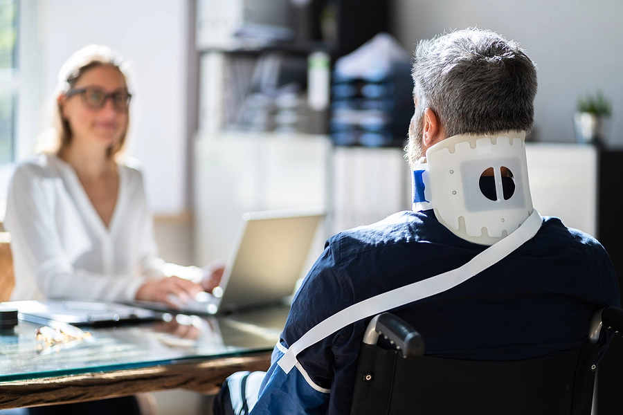 man with a neck brace and arm cast speaks to a slip and fall lawyer near where he lives about a claim