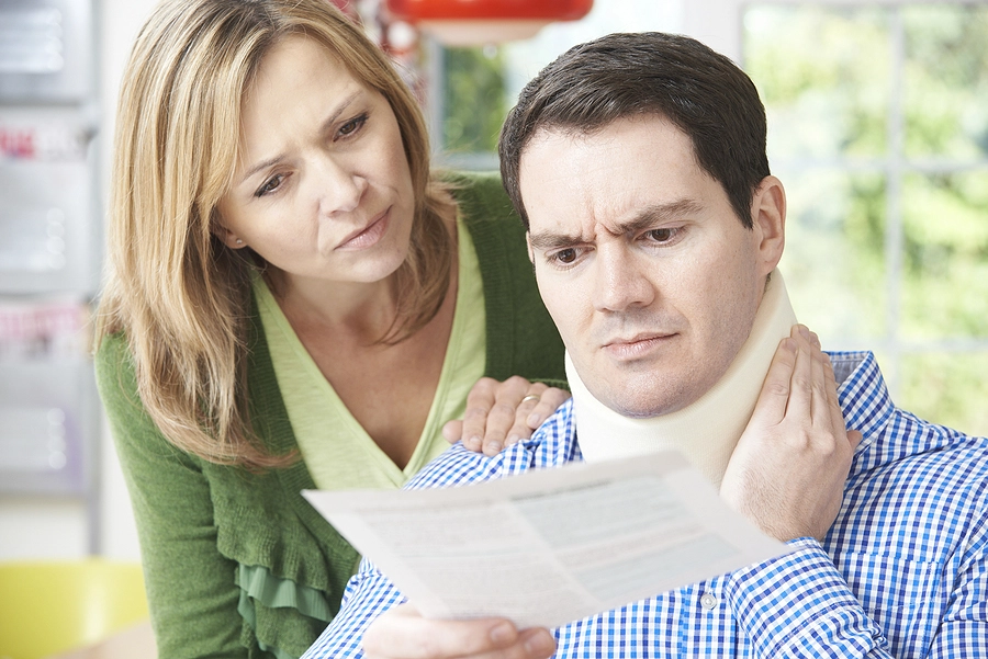 husband with a neck brace and wife looking at medical bill wondering ho to find the best car accident injury attorneys near them