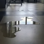 puddle of water in the middle of a dark hallway could cause a slip and fall case