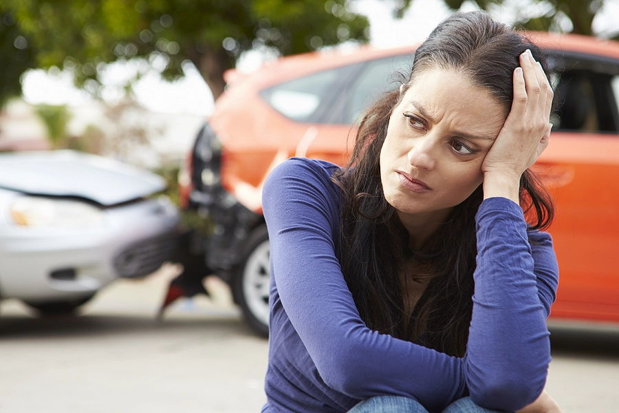 frustrated woman sits on the side of the road after a west miami rear end car accident