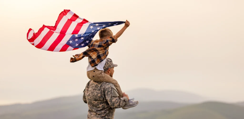 Veteran-Father-with-Son-Hold-the-American-Flag-Veteran-Benefits-Attorney-WHG-scaled