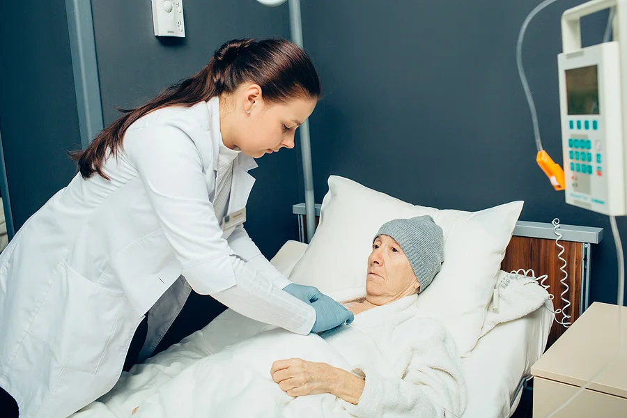 Doctor administers an injection into a cancer patient's chemotherapy port located in her chest