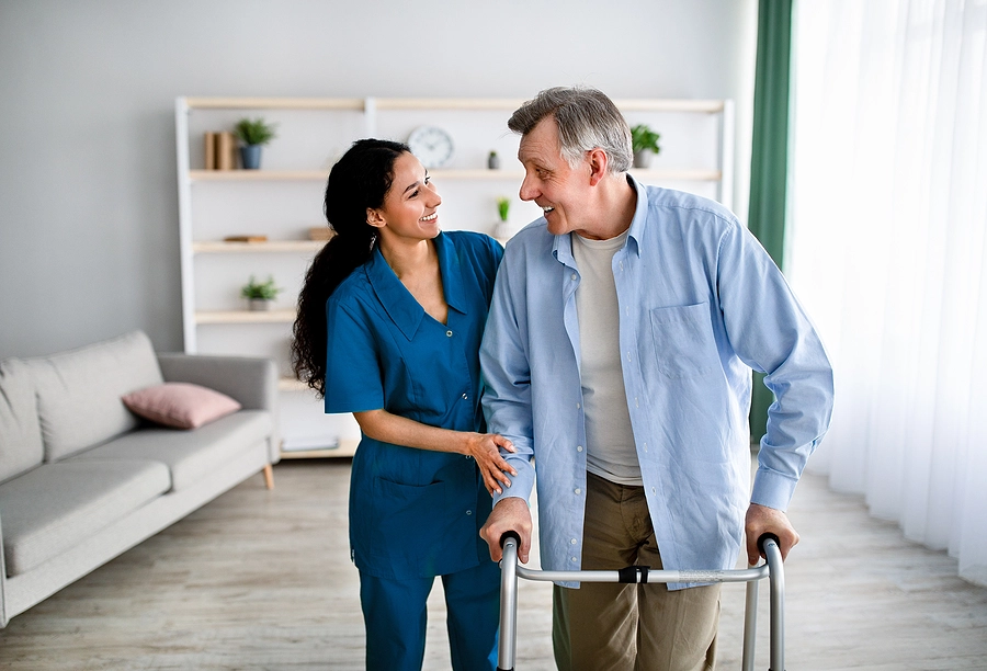 va healthcare worker helps coral gables veteran with a disability use his walker at home