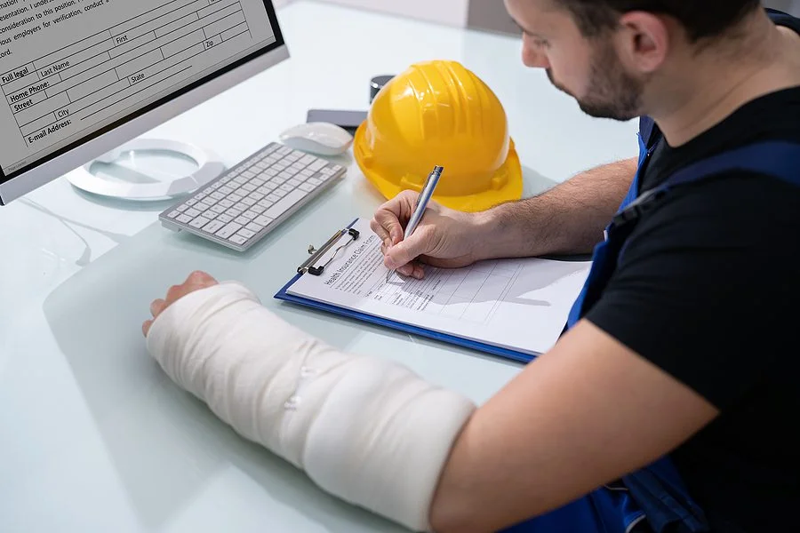 injured construction worker with a hard hat fills out a coral gables workers compensation claim