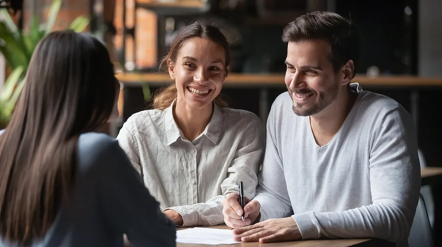 Couple speak with their lawyer in an office after receiving good news