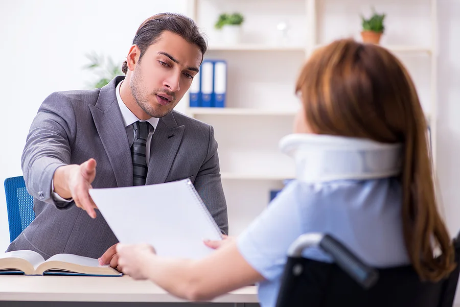 Lawyer explains a settlement offer to his injured client who is in a wheelchair