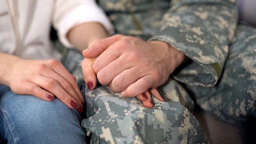 Louisiana veteran in uniform holding his wife's hand as they discuss his service-related disability