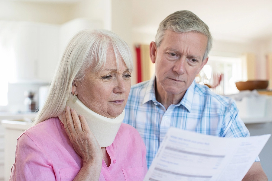 older couple looks upset while reviewing medical bills after a delray beach car accident gave the wife whiplash