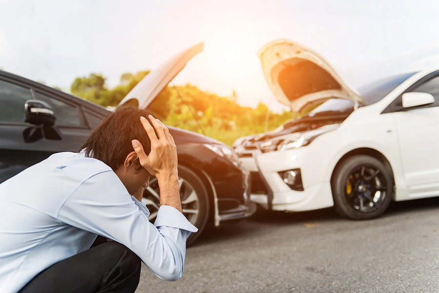 man crouching and clutching his head after a head-on palm beach gardens car accident