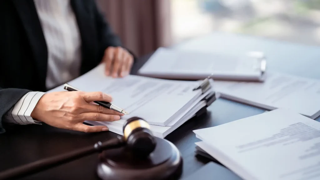 A lawyer reviewing documents on a desk with a gavel placed beside them, indicating legal work.