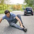 Man clutching his ankle injury in pain caused by a pedestrian accident