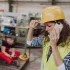 Construction worker in a hard hat calls for medical help for a co-worker who sustained injuries on the job